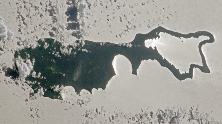 Rare sunlight trick transforms Pacific island into a giant silver 'magnifying glass' — Earth from space