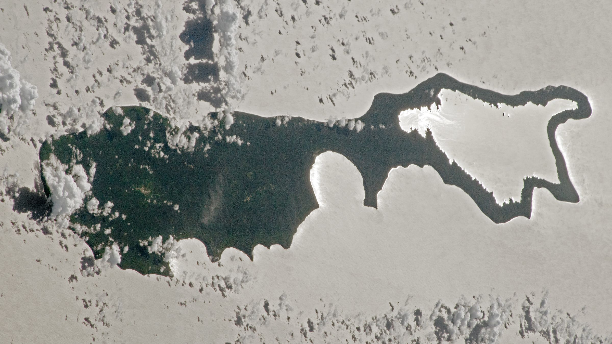 Rare sunlight trick transforms Pacific island into a giant silver 'magnifying glass' — Earth from space